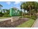 Elegant community sign for Bayou Club, surrounded by lush landscaping and mature palm trees at 9800 Sago Point Dr, Seminole, FL 33777