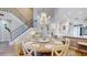 Open-concept dining room with staircase, showcasing white trim and flooring throughout at 9800 Sago Point Dr, Seminole, FL 33777