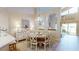 Dining room with chandelier features light wood floors and an adjacent living space overlooking the water at 9800 Sago Point Dr, Seminole, FL 33777