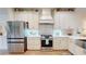 Well-lit kitchen with stainless steel refrigerator, modern gas range, stylish backsplash and cream colored cabinetry at 9800 Sago Point Dr, Seminole, FL 33777