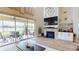 Living room features a stone fireplace, large windows, and access to an outdoor patio with water views at 9800 Sago Point Dr, Seminole, FL 33777