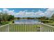 Scenic balcony view with lake panorama surrounded by lush green lawns, trees, and residential rooftops under a blue sky at 9800 Sago Point Dr, Seminole, FL 33777