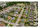 Aerial view shows neighborhood featuring lush landscaping, mature trees, manicured lawns, and community pools at 10228 Yellow Pine Way, Hudson, FL 34667