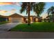 Charming home with manicured lawn and mature trees under a beautiful dusk sky at 10228 Yellow Pine Way, Hudson, FL 34667