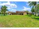 A wide expanse of green lawn showcases the beautiful front exterior of this residential home at 10228 Yellow Pine Way, Hudson, FL 34667