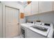 Well-lit laundry room with a washer, dryer, and storage cabinets at 10228 Yellow Pine Way, Hudson, FL 34667