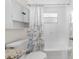 Bathroom with white shower-tub combination, floral shower curtain, and white cabinets at 10599 111Th N Ave, Largo, FL 33773