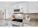 Kitchen featuring granite countertops, modern appliances, and white cabinetry at 10599 111Th N Ave, Largo, FL 33773