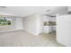 Bright living area with tile flooring flows to kitchen with white cabinetry and stainless appliances at 10599 111Th N Ave, Largo, FL 33773