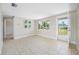 Spacious living area filled with natural light featuring tile flooring, neutral walls and access to front entry door at 10599 111Th N Ave, Largo, FL 33773