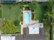 Aerial view of a lush backyard with a sparkling pool, patio area, mature trees and manicured landscaping at 10611 131St St, Largo, FL 33774
