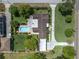 Aerial view of a home highlighting the swimming pool, patio, spacious backyard, and expansive driveway at 10611 131St St, Largo, FL 33774