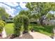 Beautifully landscaped backyard featuring a manicured lawn, privacy fence, and decorative archway covered in flowering vines at 10611 131St St, Largo, FL 33774