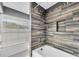 Modern bathroom showcasing a luxurious shower with designer tile surround, a white tub, and natural light at 10611 131St St, Largo, FL 33774