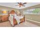 Comfortable bedroom with a ceiling fan, a large window providing natural light, and light hardwood flooring at 10611 131St St, Largo, FL 33774