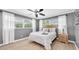 Bedroom with hardwood flooring, a ceiling fan, and a large window with sheer curtains at 10611 131St St, Largo, FL 33774