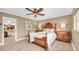 Bedroom showcasing a four-poster bed, wooden furniture, and a neutral color scheme with a view into the living area at 10611 131St St, Largo, FL 33774