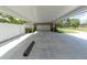Long driveway and carport leading to a two car garage with white fencing and green landscaping at 10611 131St St, Largo, FL 33774