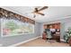 Home office featuring wood floors, a window, a modern ceiling fan, and a dark stained wood desk at 10611 131St St, Largo, FL 33774