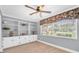 Home office space featuring built-in bookshelves, a large window, and decorative ceiling fan at 10611 131St St, Largo, FL 33774