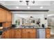 Open kitchen with black granite countertops, stainless steel dishwasher, wood cabinetry, and an open floorplan at 10611 131St St, Largo, FL 33774