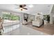 Bright living room featuring a stone fireplace, ceiling fans, and access to the outdoor pool area at 10611 131St St, Largo, FL 33774