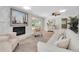 Cozy living room with a stone fireplace, neutral furnishings, wood floors, and an artful sailboat print at 10611 131St St, Largo, FL 33774
