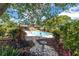 Inviting backyard pool with a paved deck, lush landscaping, and birdbath, perfect for relaxation and entertaining at 10611 131St St, Largo, FL 33774