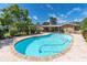 Sparkling pool surrounded by mature trees and manicured landscaping offers a private oasis at 10611 131St St, Largo, FL 33774