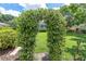 Charming floral archway leading to a lush green yard, creating an inviting and picturesque outdoor setting at 10611 131St St, Largo, FL 33774