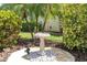 Decorative birdbath surrounded by lush foliage, adding a serene and charming touch to the landscape at 10611 131St St, Largo, FL 33774