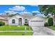 Well maintained single-story home with a well-manicured lawn, arched entryway, and two car garage at 10621 Ribbon Fern Way Way, Land O Lakes, FL 34638