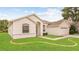 Single-story home featuring a manicured lawn and an attached two car garage at 10621 Ribbon Fern Way Way, Land O Lakes, FL 34638