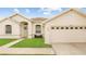 Charming single-story home with a well-manicured lawn, arched entryway, and attached two car garage at 10621 Ribbon Fern Way Way, Land O Lakes, FL 34638