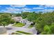 An aerial view of a well-maintained home featuring a manicured lawn and mature trees in a suburban neighborhood at 10621 Ribbon Fern Way Way, Land O Lakes, FL 34638