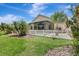 Lush backyard features a white fence, tropical landscaping, and a glimpse of the screened lanai at 10734 Banfield Dr, Riverview, FL 33579