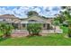 A view of the screened in patio, mature landscaping, and lush lawn in the backyard at 10734 Banfield Dr, Riverview, FL 33579