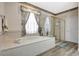 A luxurious bathroom offers a soaking tub and a glass enclosed shower, with natural light and new vinyl floors at 10734 Banfield Dr, Riverview, FL 33579