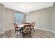 Dining room features a chandelier, shuttered window, hardwood floors, and a dining table with four chairs at 10734 Banfield Dr, Riverview, FL 33579