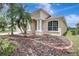 Beige home exterior featuring an arched entrance supported by white columns with palm trees on a well manicured lawn at 10734 Banfield Dr, Riverview, FL 33579