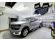 Well-organized garage featuring a silver truck, storage racks, and a tidy space with a multi-panel garage door at 10734 Banfield Dr, Riverview, FL 33579