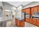 Open concept kitchen with stainless steel appliances, wooden cabinetry, and an island at 10734 Banfield Dr, Riverview, FL 33579