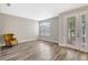 Cozy living room filled with natural light with hardwood flooring and a statement chair adjacent to the decorative front door at 10734 Banfield Dr, Riverview, FL 33579