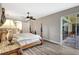 Spacious bedroom features wood floors, a ceiling fan, and glass patio doors, offering seamless indoor-outdoor living at 10734 Banfield Dr, Riverview, FL 33579