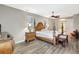 A well-lit bedroom features a four-poster bed, elegant nightstands, and stylish decor on sleek wood flooring at 10734 Banfield Dr, Riverview, FL 33579