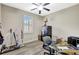Functional office space featuring a safe, a ceiling fan, natural light, and laminate flooring for a productive work environment at 10734 Banfield Dr, Riverview, FL 33579