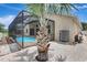 View of the screened patio area with tropical palm, brick pavers, and home exterior at 10734 Banfield Dr, Riverview, FL 33579