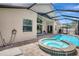 Inviting pool and spa area with brick pavers and screened enclosure, enhancing outdoor living at 10734 Banfield Dr, Riverview, FL 33579