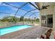 Relaxing screened pool area featuring a spa, brick pavers, ceiling fan, and outdoor access at 10734 Banfield Dr, Riverview, FL 33579