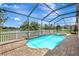 Screened pool with spa offers a serene backyard view featuring palm trees and a white picket fence at 10734 Banfield Dr, Riverview, FL 33579